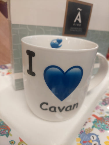 White mug with 'I ❤️ Cavan' text on a colorful surface