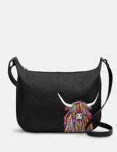 Load image into Gallery viewer, Black handbag with a colorful highland cow design on a white background

